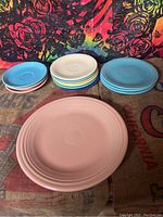 Overview of stacked and separated Fiesta ware dishes showing pastel colors pink, blue, turquoise, white, yellow, and green.