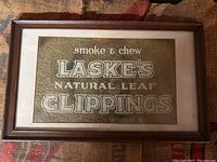 Framed vintage tobacco advertising sign with white text on felt background