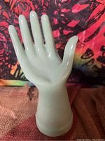 Front angled view of the jadeite hand display showing smooth, glossy pale green finish and finger details.