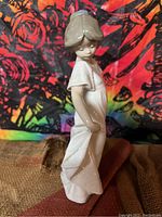 Side profile of the Nao Lladro porcelain girl figurine showing flowing dress and hair detail.