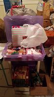 Purple plastic storage container filled with holiday items in a basement storage area