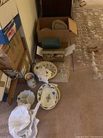 Photo showing boxed items with various Christmas themed Lenox bowls and plates and decorative vase