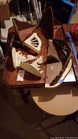 Five wood items including white painted carved sconces and three wood shelves with various shapes, finishes and wear.