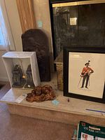 Shows the vintage metal storage box, framed soldier wall art, wooden sculpture, decorative metal relief panel, and original boxed wall sconces all arranged on fireplace hearth.