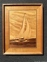 Full view of the framed wood inlay sailboat artwork showing wood grain, sailboat details, and frame.