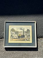 Framed colored print of "The Rocket" locomotive engine circa 1830, showing scene with people in period attire and village background.