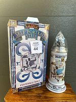 Front view showing stein and its colorful box featuring artwork and title.