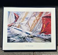 Full view of a framed poster titled 'On the Edge' by Willard Bond showing a sailboat with red sails on the edge of a wave.