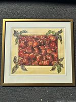 Framed print of numerous ripe apples with gold accented leaves around the border.
