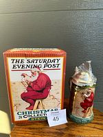 Photo of the Saturday Evening Post Christmas Collection box and the decorated Santa Claus lidded stein.