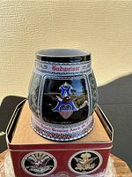 Front side view of ceramic stein showcasing the Anheuser-Busch eagle emblem and embossed detailing with color accents.