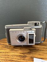 Front view of the vintage Polaroid Electric Land Camera showing lens, viewfinder, and body details.