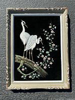 Full view of framed velvet painting showing two white birds on a blossoming branch.
