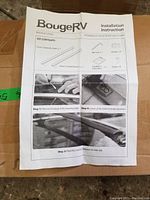 Photo showing the BougeRV installation instruction sheet for the crossbar kit, listing kit contents and installation steps with images.