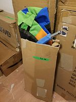 Folded 40 inch saucer swing seat with visible colorful fabric in a cardboard box, showing brand packaging and product storage.