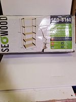 Photo of the packaging box showing shelf model, dimensions and Seowood branding