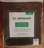 Photo of Serta Sertapedic King sheet set packaging showing brand, size, and fabric content label (65% cotton, 35% Tencel). Black color sheets visible through packaging.