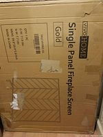 Photo of cardboard packaging box labeled Vivohome Single Panel Fireplace Screen Gold with product details and sketch of screen