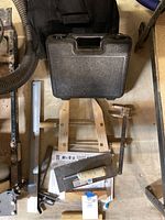 Black hard plastic carrying case closed on workshop floor