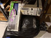 Coleman camping stove box next to other camping gear on storage shelf.