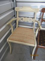Full view of painted accent chair showing armrests, carved legs, and removable woven seat cushion.