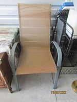 Outdoor patio chair with grey metal frame and tan mesh fabric seat and backrest.