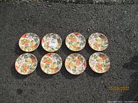 Eight Pamela Gladding SBCD Fall Leaves collectible plates arranged in two rows of four on asphalt, each 6 inches diameter, colorful fall leaves design.
