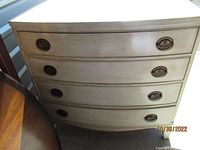 Front view showing four curved drawers and painted finish