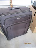 Full view of Samsonite suitcase showing front pockets, spinner wheels, and overall soft expandable structure.