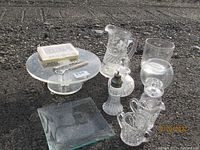 Showing full lot with sterling silver items, glassware including pitcher, vases, and trays