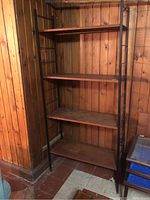 Full view of shelf unit against wood paneled wall