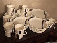 Wide view of multiple  pieces of Wedgwood Parallels dinnerware including mugs, plates, bowls, and cups.