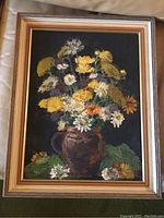 Full view of framed original still life painting showing a bouquet of yellow, white, orange and purple flowers in a dark vase against a black background.