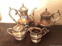 All four pieces together on table: coffee pot, teapot, creamer, sugar bowl.