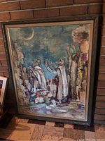 Front view of framed painting leaning against brick wall and tiled floor