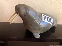 Front-right angled view showing facial details, ivory tusks and flipper feet with sticker “700”