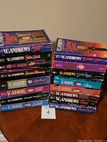 Stack of 14 V.C. Andrews paperback books showing colorful covers and titles visible on spine.