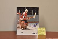 The lot displaying an 8x10 color photo of Bernie Parent in goalie stance with his signature and HOF 84 inscription, alongside a yellow certificate of authenticity card.