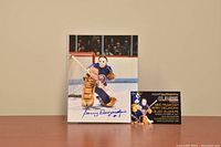 Color 8x10 photo of Gerry Desjardins in goalie gear, signed, with certificate of authenticity card beside it.