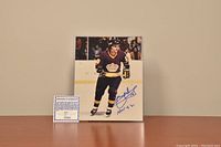 Photo of signed 8x10 color photograph of Marcel Dionne in Kings uniform, with blue ink signature and 'HOF 92' inscription, next to Certificate of Authenticity.