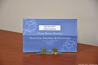Photo of $50 gift certificate card from Boniebrae Daylilies & Perennials on a wooden surface.