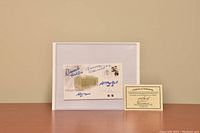 Photo showing the Canada Post Chicago Stadium First Day Cover signed by four hockey Hall of Famers along with the certificate of authenticity placed side by side on a table.