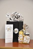 Photo of the honey jar and beeswax candle gift set with brand packaging and informational materials on a table.