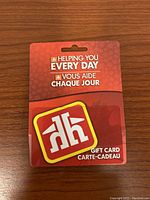 Front view of Home Hardware $250 gift card in original sealed packaging on wood surface