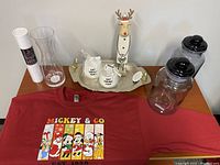 Full view of the lot on wooden surface including sweatshirt, jars, sangria carafe, wine cups, wooden moose decor and platter