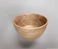 Single handcrafted maple wood salad bowl with natural wood grain visible, photographed against a neutral background.