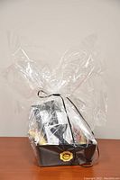 Image of the wrapped gift basket with pet items inside, showing plastic wrap and ribbon securing the contents.