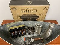 Front view of galvanized metal 'Party Boat' tub containing beverage accessories and portable barbecue box