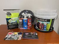 Full kit items displayed on table: chenille wash mitt, spray bottles, applicator pad, and bucket.