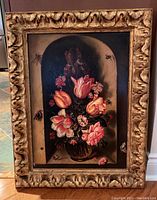 Framed oil painting showing a bouquet of tulips with bees and butterflies in a niche-like setting, carved and gilded wood frame.